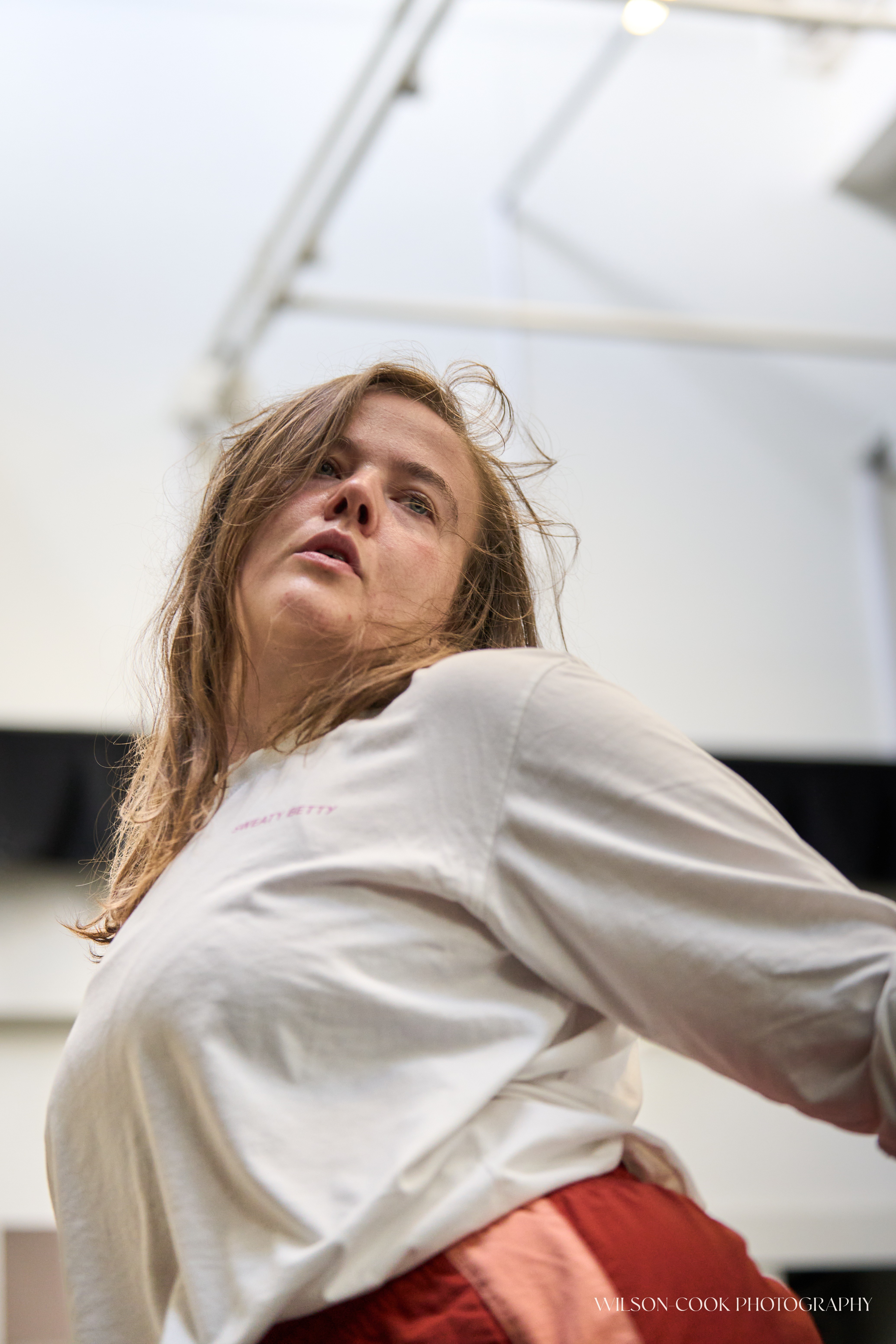 2025.  A dancer, mid-movement, the photo is shot pointing up towards the dancer's face, and they are looking towards their left.