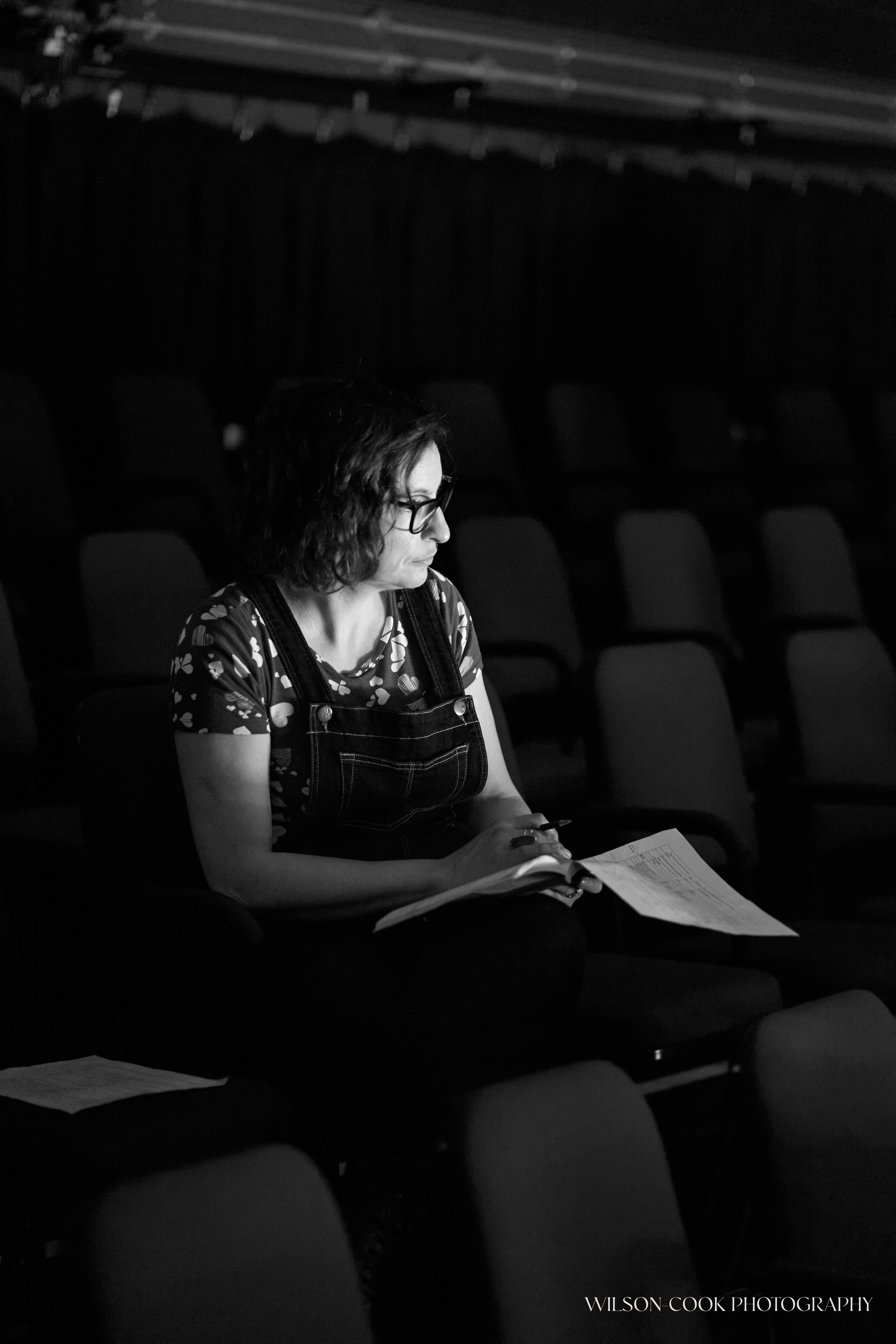 2025. A black and white image of a woman in an auditorium.